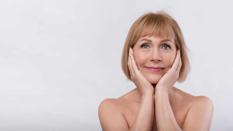 woman with her hands cupping her chin and jawline