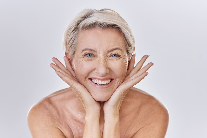 smiling woman with hands on chin and jawline
