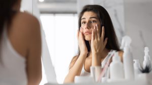 woman applying skin products to face