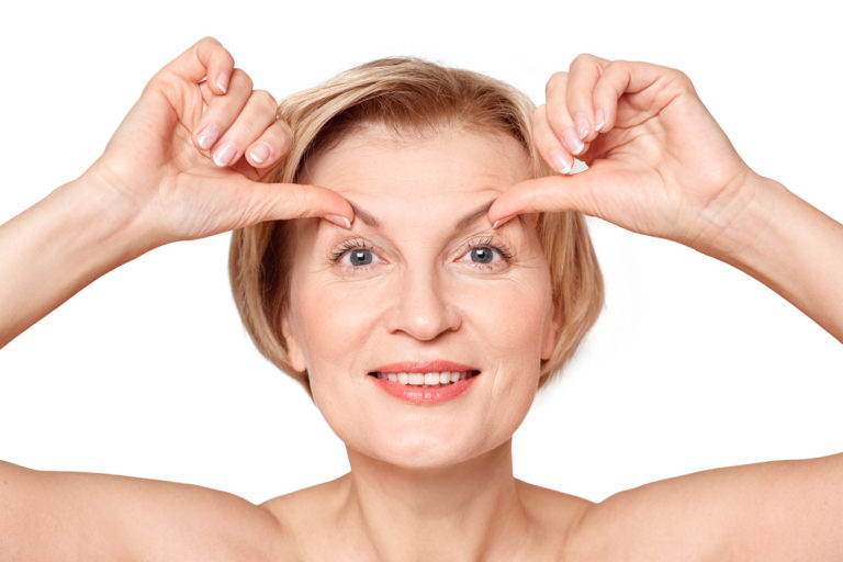 woman pulling eyebrows up with her thumbs