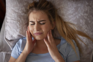 woman grinding teeth in bed