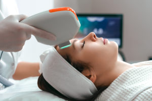 woman receiving ultrasound treatment for an eye brow lift